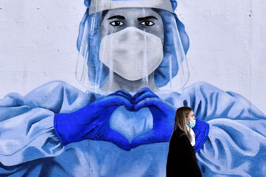 A woman walks past a mural depicting a frontline worker amid the spread of the coronavirus disease (COVID-19) in Dublin, Ireland, January 12, 2022. REUTERS/Clodagh Kilcoyne