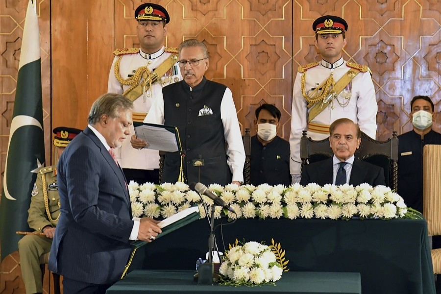 In this photo released by Press Information Department, Pakistan's President Arif Alvi, centre, administrates oath from newly appointed Finance Minister Ishaq Dar, left, as Prime Minister Shehbaz Sharif, right, watches during a ceremony in Islamabad, Pakistan, Wednesday, Sept 28, 2022.  (Press Information Department vis AP)