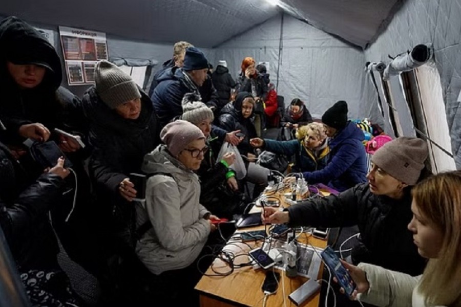 Local residents charge their devices, use internet connection and warm up inside an invincibility centre after critical civil infrastructure was hit by Russian missile attacks in Kyiv, Ukraine Nov 24, 2022. REUTERS/Valentyn Ogirenko