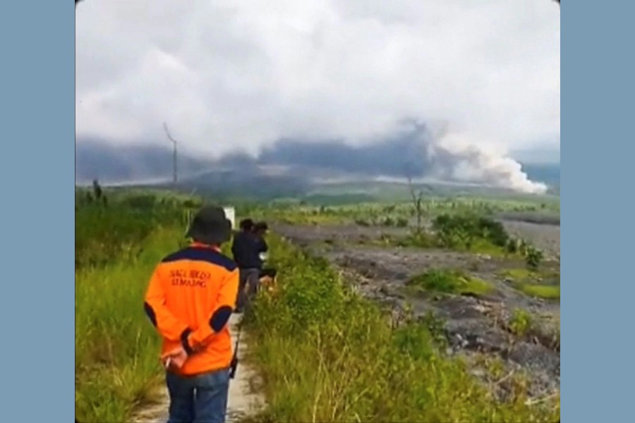 People look on as volcanic ash fills the sky during an eruption of the Semeru volcano in Lumajang, East Java Province, Indonesia December 4, 2022 in this screen grab obtained from a social media video. Instagram/@Gustiallah Foundation/via REUTERS
