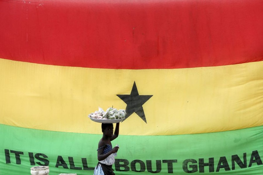 A girl walks past a flag of Ghana outside the Cape Coast Castle, in Ghana, July 28, 2019. REUTERS/Siphiwe Sibeko