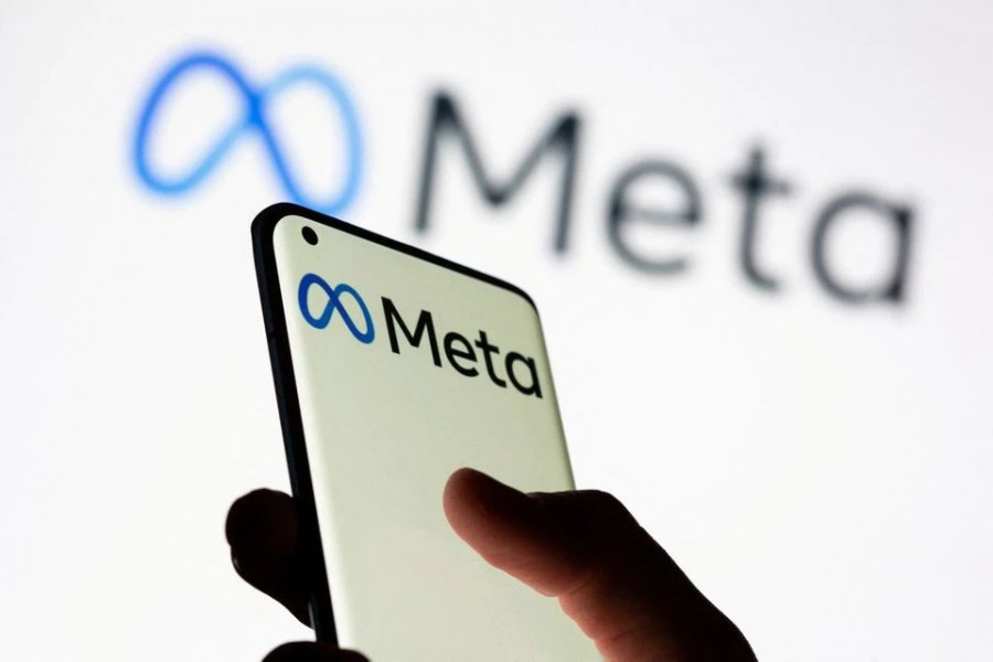 Woman holds smartphone with Meta logo in front of a displayed Facebook's new rebrand logo Meta in this illustration picture taken on October 28, 2021 — Reuters photo