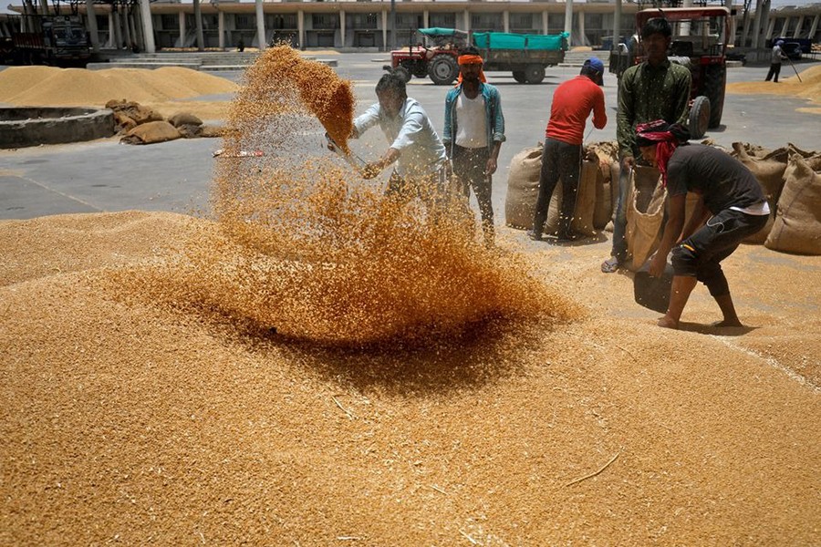 Workers sift wheat before filling in sacks at the market yard of the Agriculture Product Marketing Committee (APMC) on the outskirts of Ahmedabad, India on May 16, 2022 — Reuters/Files