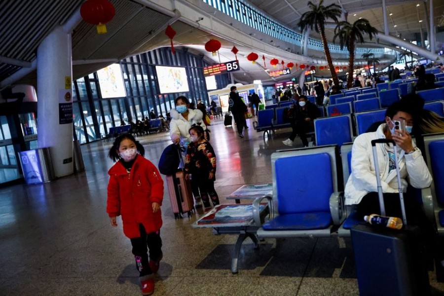 A child walks while people wait with their luggages at a railway station, amid the coronavirus disease (Covid-19) outbreak, in Wuhan, Hubei province, China on January 1, 2023 — Reuters photo