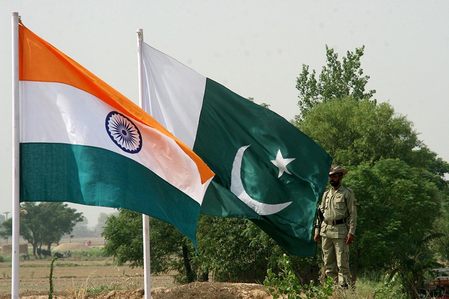 A Pakistani ranger is seen standing near Indian (L) and Pakistani flags during a fair in Chamliyal in Jammu and Kashmir in this June 22, 2006 file photo — Reuters