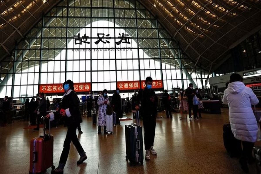 People wait with luggages at a railway station, amid the coronavirus disease (COVID-19) outbreak, in Wuhan, Hubei province, China January 1, 2023. REUTERS/Tingshu Wang