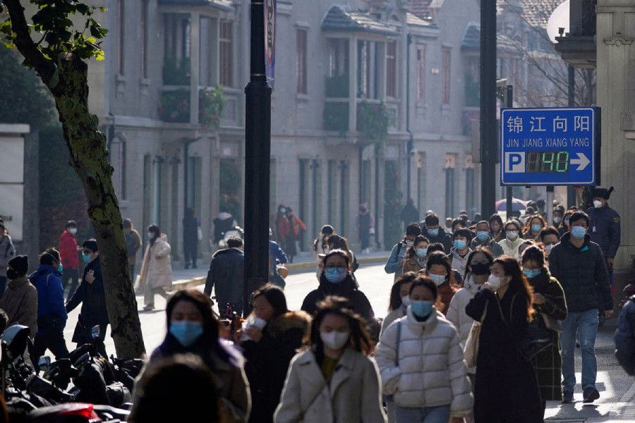 People wearing face masks walk on a street, as coronavirus disease (COVID-19) outbreaks continue in Shanghai, China, December 13, 2022. REUTERS/Aly Song/File Photo