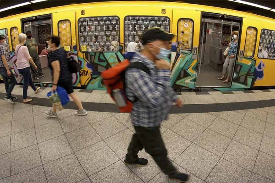 People wearing face masks to protect themself against the coronavirus as they leave and get on board a subway train in Berlin on June 23 in 2020 -AP file photo