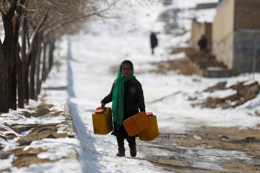 An Afghan girl carries empty water containers on a snow-covered street in Kabul, Afghanistan on January 26, 2023 — Reuters photo