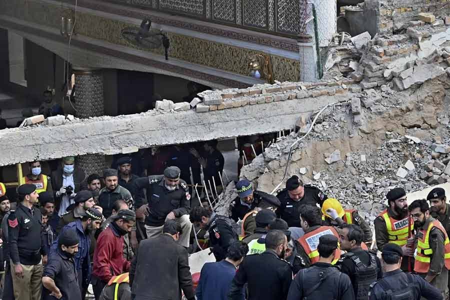 Security officials and rescue workers searching bodies at the site of suicide bombing in Peshawar of Pakistan on Monday -AP photo