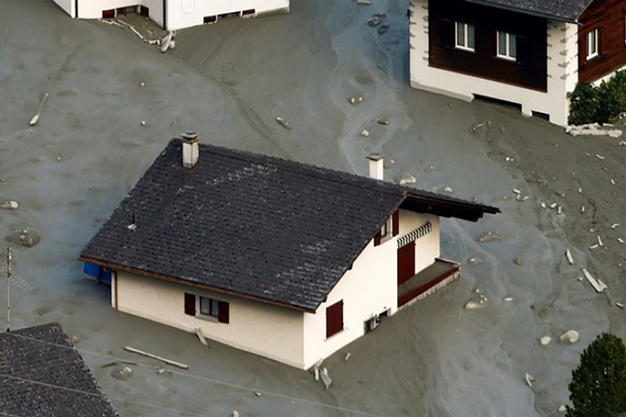 A house is surrounded by debris of a landslide in the village of Bondo on Saturday.