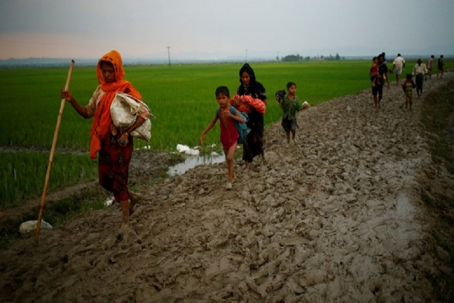 A Rohingya refugee walks on the muddy path after crossing the Bangladesh-Myanmar border in Teknaf. Reuters