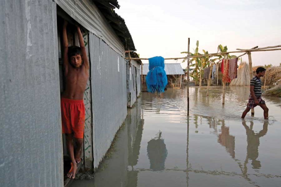 A boy stands in the door of his flooded house in Bogra, Bangladesh, August 20, 2017. 	—Reuters photo