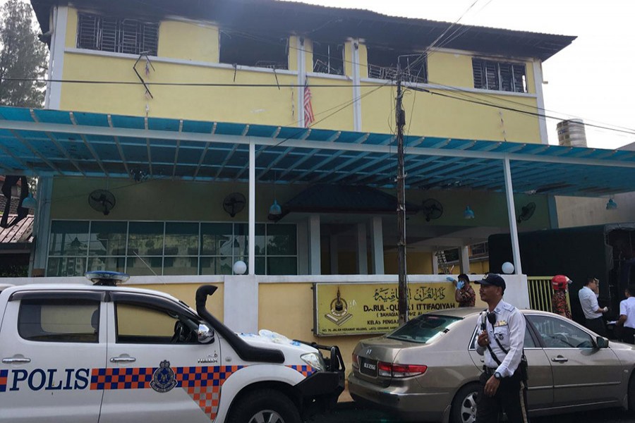 Police and fire department work at the religious school Tahfiz Darul Quran Ittifaqiyah after a fire broke out in Kuala Lumpur, Malaysia early Thursday. - Reuters photo