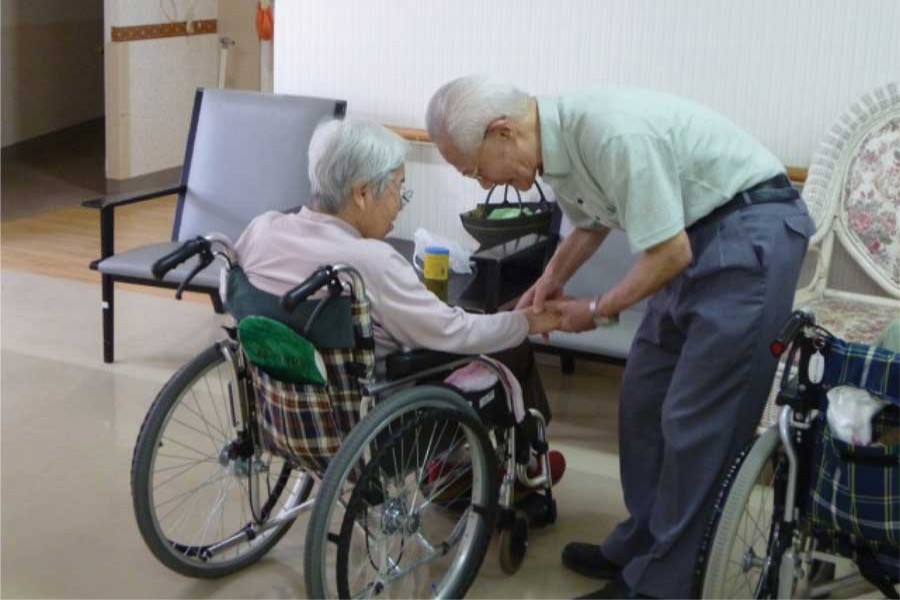 An elderly woman and a man at a nursing home in Tokyo: Japan to create more user-friendly elderly care robots