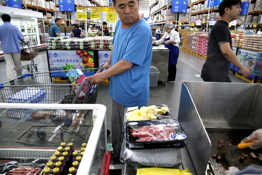 A customer looks at the beef steaks for sale at a Sam's Club store of Wal-Mart in Beijing, China. - Reuters file photo