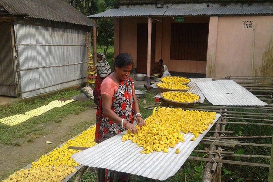 NATORE: A housewife dries lentil dumpling in Boraigram upazila on Saturday.	— FE Photo
