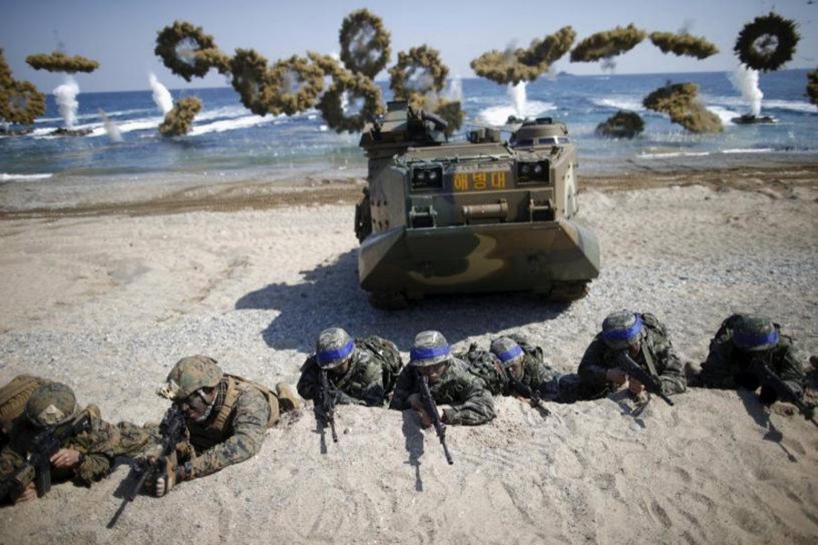 South Korean (blue headbands) and US Marines take positions during a US-South Korea joint landing operation drill in Pohang, South Korea on March 12, 2016. - Reuters file photo