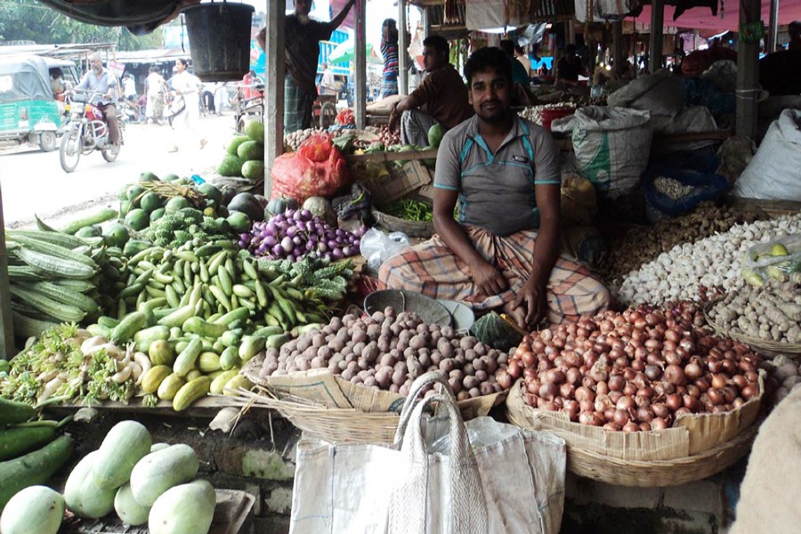 A vendor waits for customers at his shop in a kitchen market in Bogra Sadar on Wednesday.	— FE Photo