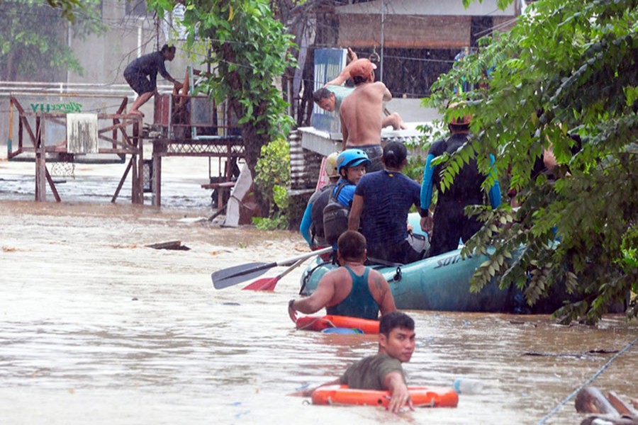 Rescuers evacuate residents from their homes during heavy flooding in Cagayan de Oro city in the Philippine