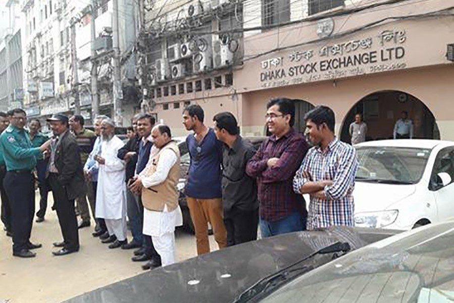 Police are seen calming some small investors trying to stage demonstrations in front of Dhaka Stock Exchange Building on Monday as share prices continue to fall for the five straight sessions. Photo: FE