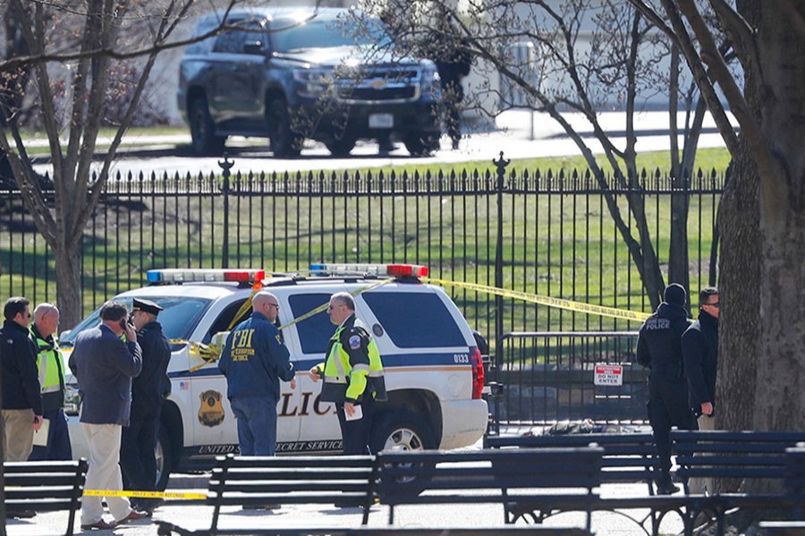 Lawmen gather in front of the White House in Washington, after the area was closed to pedestrian traffic on Saturday. - AP photo