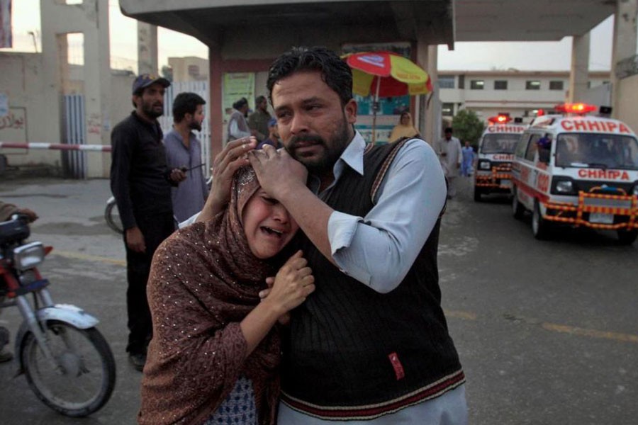A man comforts a Christian woman who lost her husband in a deadly shooting incident, outside a hospital in Quetta, Pakistan, Sunday, April 15, 2018. AP photo.