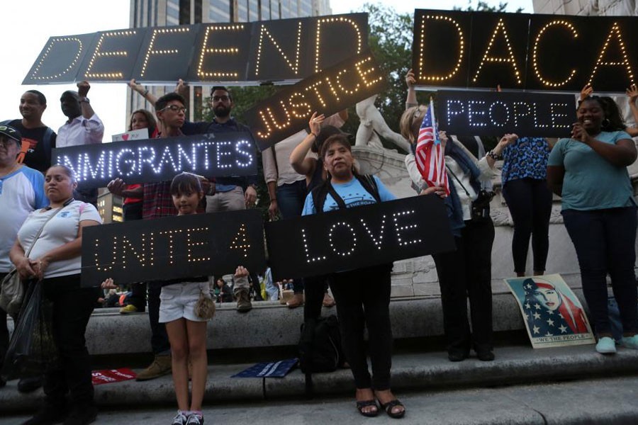 People hold signs against US President Donald Trump’s proposed end of the DACA program that protects immigrant children from deportation at a protest in New York City, US, August 30, 2017. Reuters.
