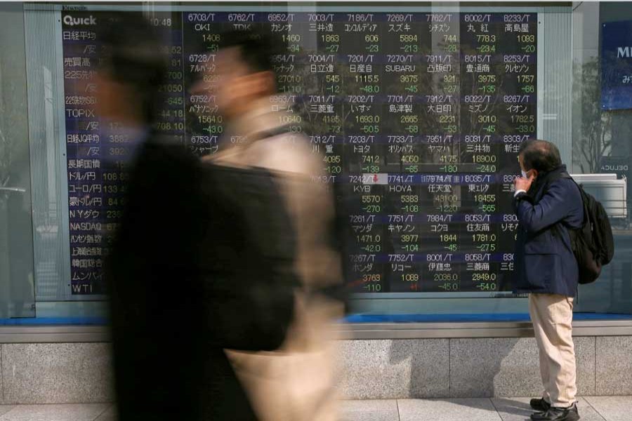 A man looks at an electronic stock quotation board outside a brokerage in Tokyo, Japan February 9, 2018. Reuters/Files
