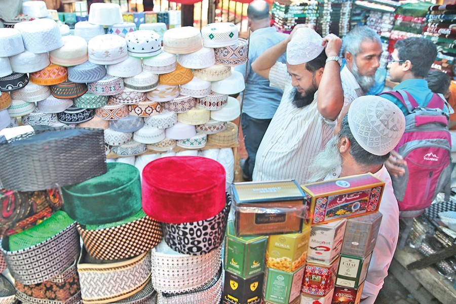 A man trying on a prayer cap at a makeshift shop in Baitul Mukarram area in the city on Thursday — FE Photo
