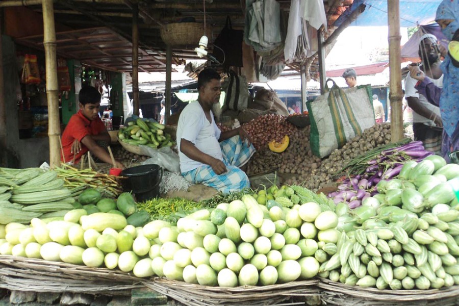 A seller waiting for customers at his vegetable shop in Khojanpur Kitchen Market under Joypurhat Sadar on Monday  	— FE Photo