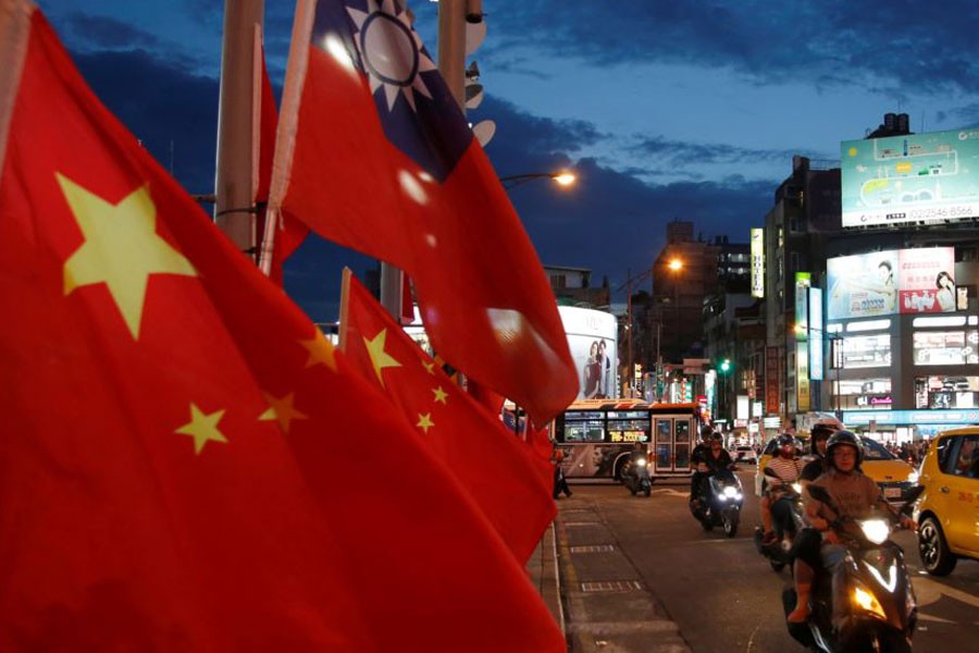 Flags of China and Taiwan flutter next to each other during a rally calling for peaceful reunification, days before the inauguration ceremony of President Tsai Ing-wen, in Taipei, Taiwan, May 14, 2016 – Reuters file photo
