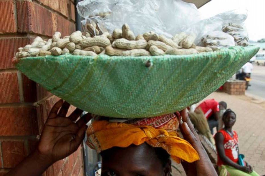 n this photo taken Saturday, Oct. 20, 2018, Irene Atenyo, 27, whose husband is involved with another woman, carries the boiled ground nuts she sells for a living on the streets of Kampala, Uganda. Millions of women across sub-Saharan Africa are still living in the complex relationships of polygamy, a centuries-old practice that once was the norm among African men seeking large families to cultivate land.  - AP Photo