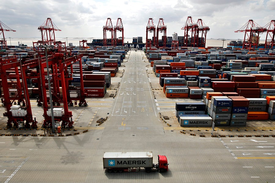 A container truck drives past the container area at the Yangshan Deep Water Port, part of the newly announced Shanghai Free Trade Zone, south of Shanghai on September 26, 2013 — Reuters/File
