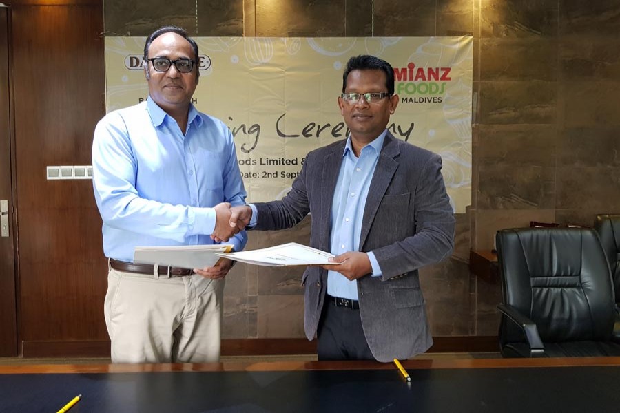 Firoz Ahmed, Chief Operating Officer (COO) of Dan Foods Limited, and Ahmed Mottaki, CEO and Chairman of Mianz Pvt Limited, exchanging documents after signing the contract of behalf of their respective companies.