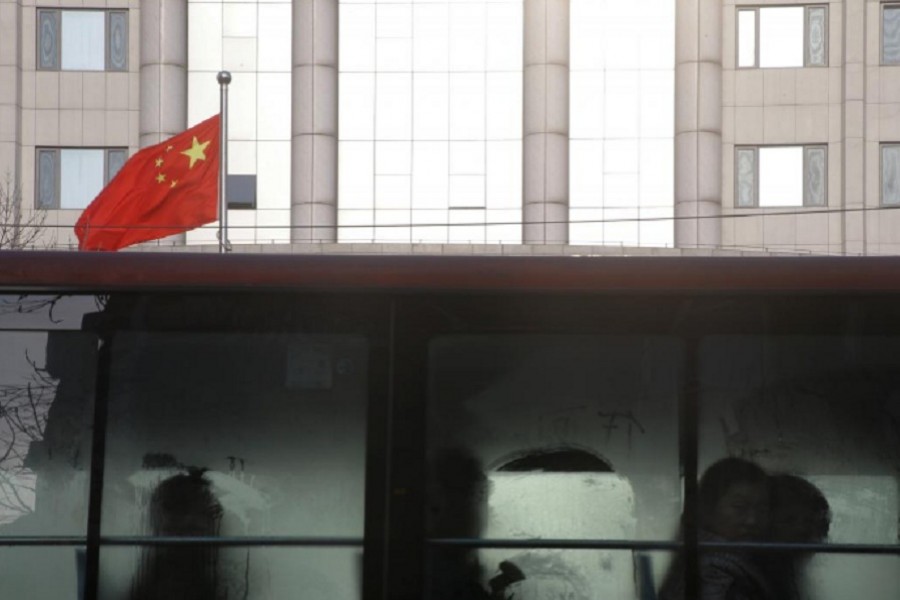 People sit in a bus driving past the courthouse where prominent rights lawyer Wang Quanzhang is being tried in Tianjin, China on December 26, 2018. - Reuters