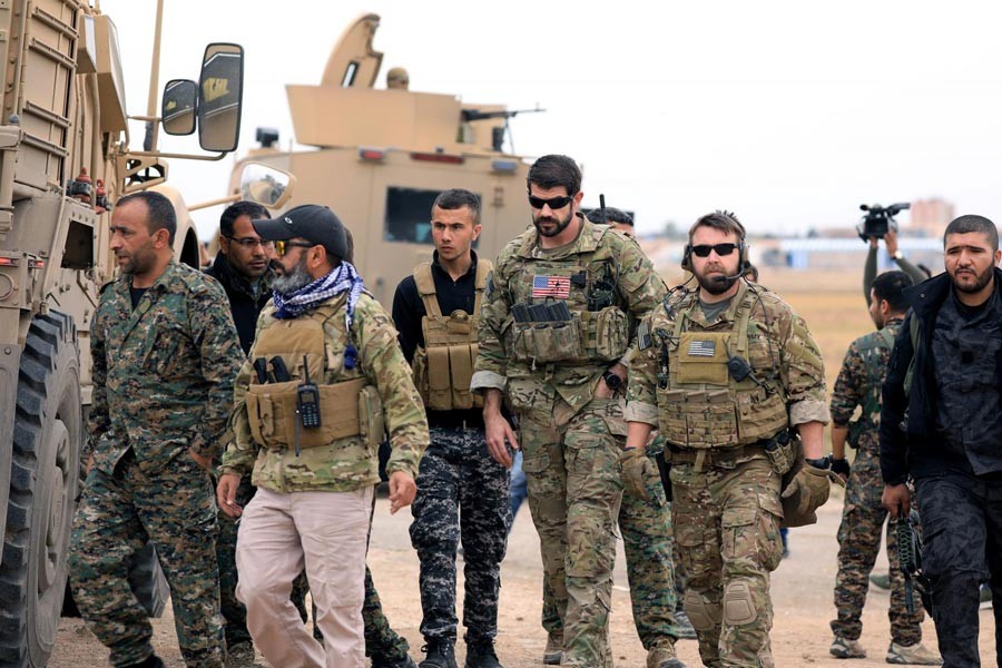 A file photo showing Syrian Democratic Forces and US troops seen during a patrol near Turkish border in Hasakah, Syria recently	— Reuters