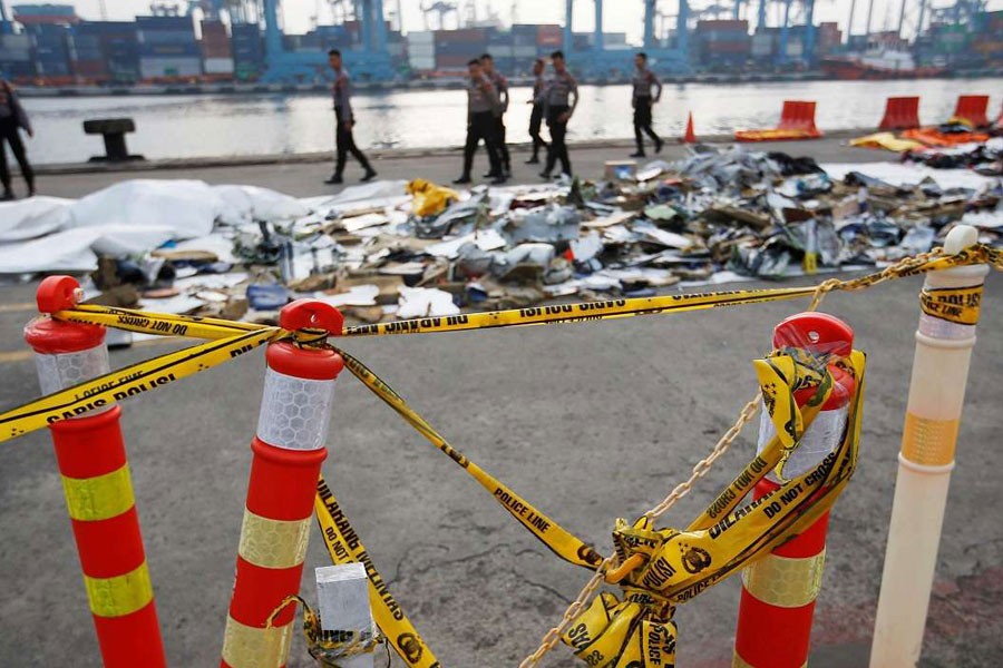 Police line is seen as Indonesian policemen walk near recovered debris and belongings of Lion Air flight JT610, that crashed into the sea, at Tanjung Priok port in Jakarta, Indonesia, October 31, 2018 - Reuters