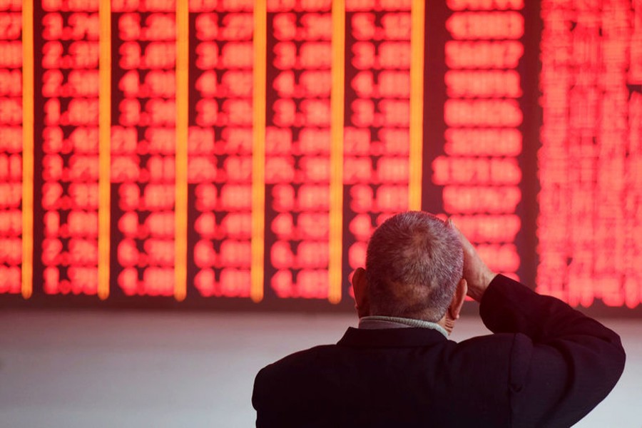 A man sits in front of an electronic board showing stock information at a brokerage house in Hangzhou, Zhejiang province, China, December 3, 2018. Reuters/Files