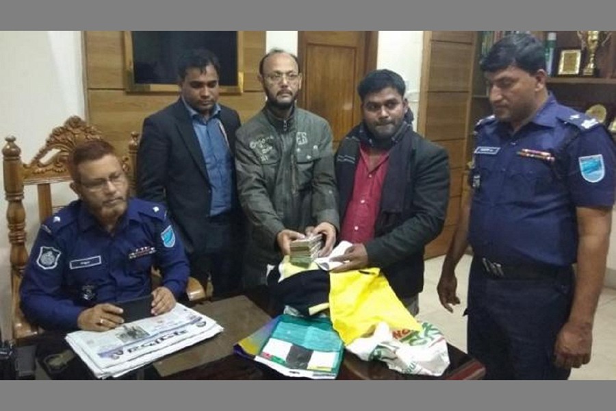 Sarwar Jahan, a bank official deposits the bag at the Fatullah Model Police Station to find out the owner of the money. Photo: Courtesy