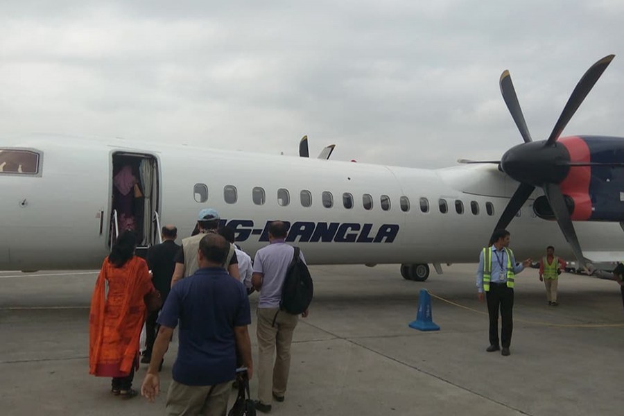 Passengers stand in a queue to board a domestic flight of US-Bangla Airlines — Collected