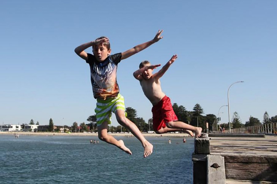 Boys jump into the water off Altona pier in Melbourne, Australia to cool themselves off during a hot summer day — Reuters/File