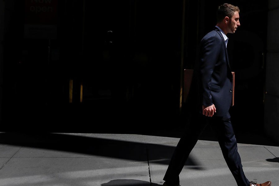 A man in a suit walks on Wall St in New York City, US, August 23, 2018 - REUTERS/Brendan McDermid