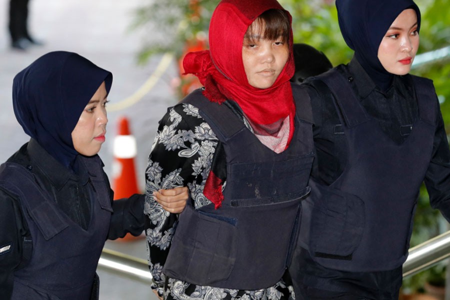Vietnamese Doan Thi Huong, center, is escorted by police as she arrives at Shah Alam High Court in Shah Alam, Malaysia, Thursday, March 14, 2019. Vietnam has urged Malaysia to release the second woman accused of killing the estranged half brother of North Korea's leader after her co-defendant was unexpectedly set free this week - AP Photo/Vincent Thian