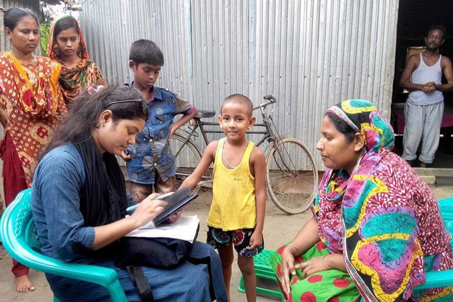 An enumerator recording data in a village of Bangladesh
