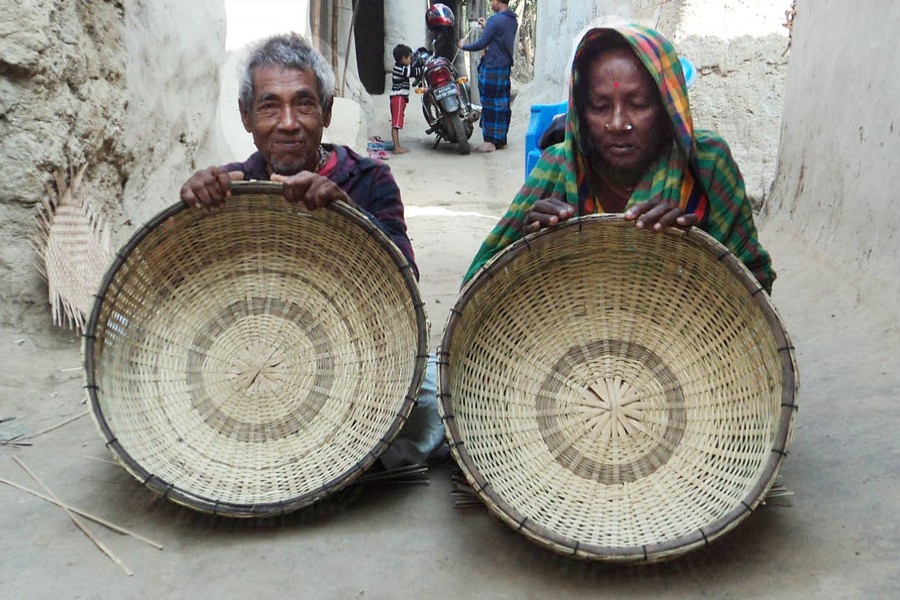 A couple of bamboo basket makers showing their products in Panchbibi upazila of Joypurhat on Wednesday    	— FE Photo