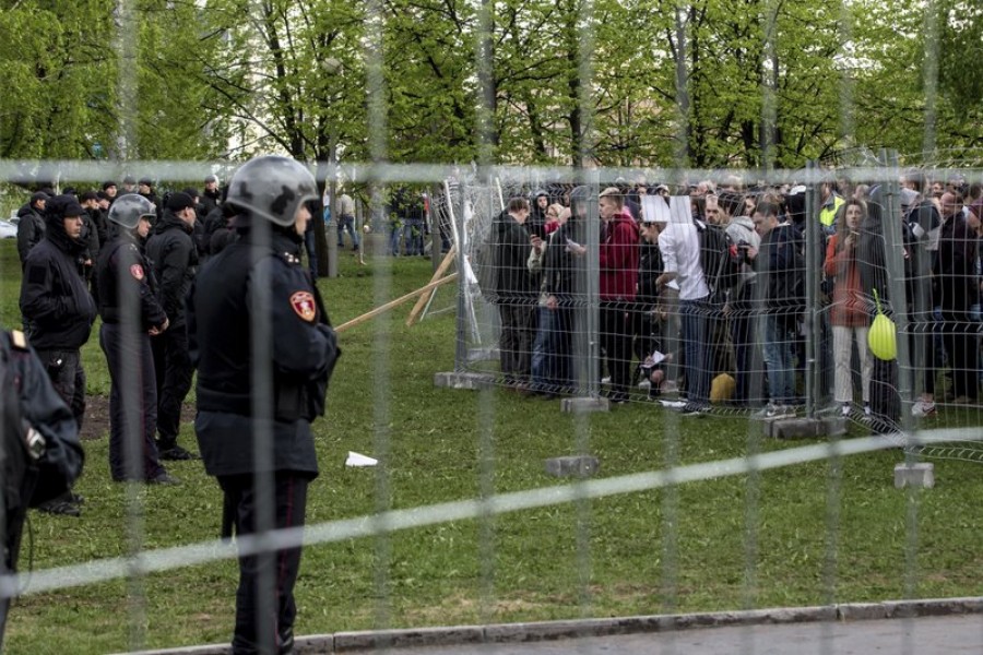 Demonstrators, right, stand in front of a fence blocked by police protesting plans to construct a cathedral in a park in Yekaterinburg, Russia, Tuesday, May 14, 2019. Demonstrators tore down fences set up to protect the construction site as police tried to wrest the fences away - AP Photo/Anton Basanayev