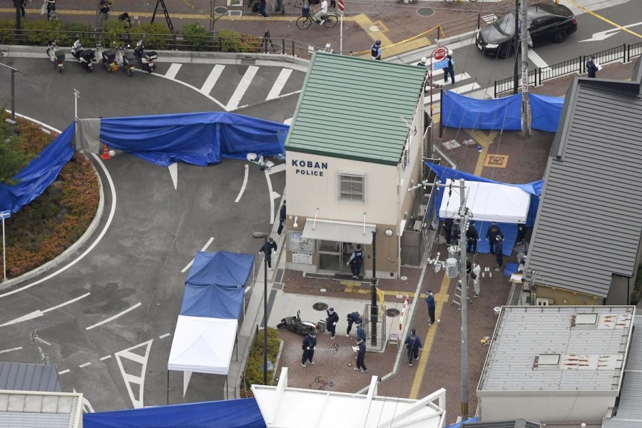 An aerial view shows police officers investigating the site where a police officer was found stabbed in front of a police box and the officer's gun, loaded with several bullets, was stolen, in Suita, Osaka prefecture, western Japan June 16, 2019, in this photo taken by Kyodo - Mandatory credit: Kyodo/via REUTERS