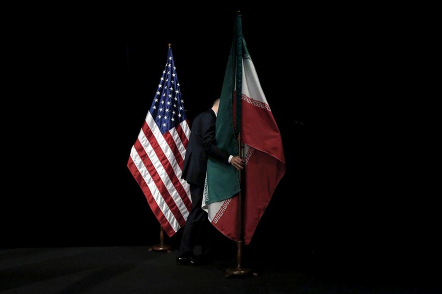 A staff member removes the Iranian flag from the stage during Iran nuclear talks at the Vienna International Center in Vienna, Austria on July 14, 2015 — Reuters/Files