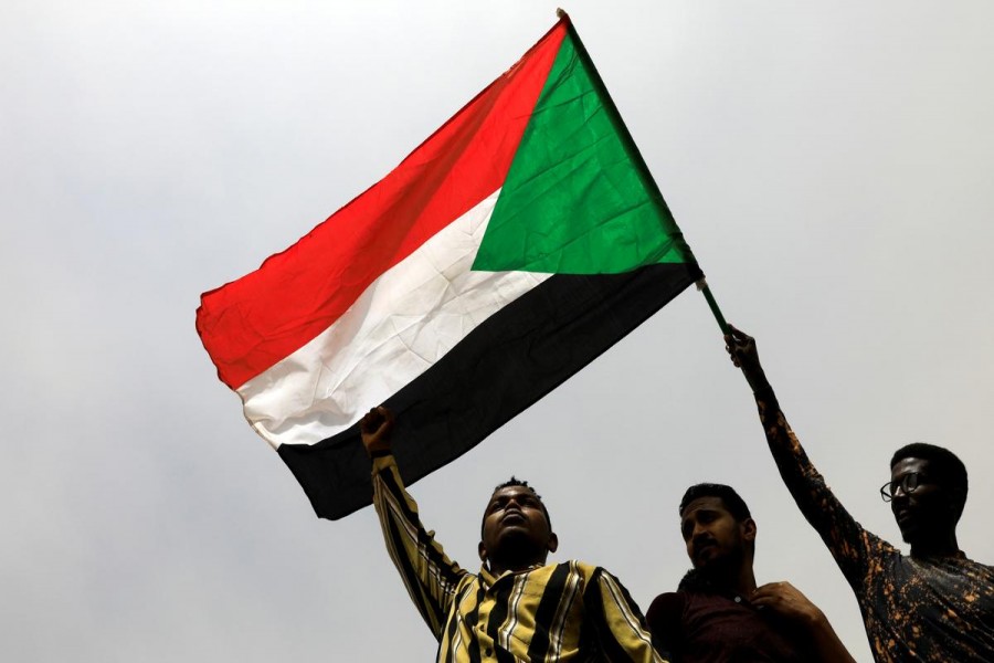Demonstrators hold Sudanese flag as they march on the streets demanding the ruling military hand over to civilians, in Khartoum, Sudan, June 30, 2019 - REUTERS/Umit Bektas